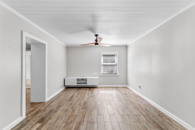 spare room with ceiling fan, crown molding, and wood finished floors