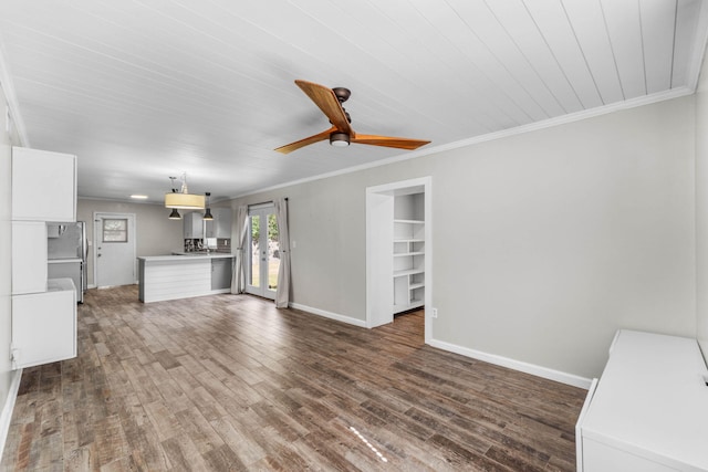 unfurnished living room with ornamental molding, dark wood finished floors, baseboards, and a ceiling fan