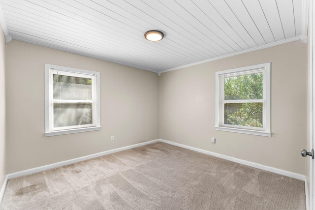 carpeted spare room with baseboards and crown molding