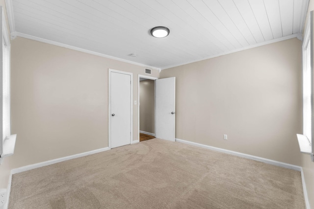 unfurnished bedroom with carpet floors, baseboards, and ornamental molding