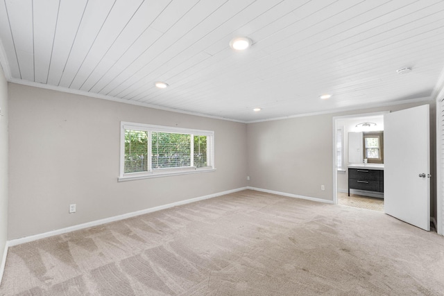 unfurnished room featuring baseboards, ornamental molding, and light colored carpet