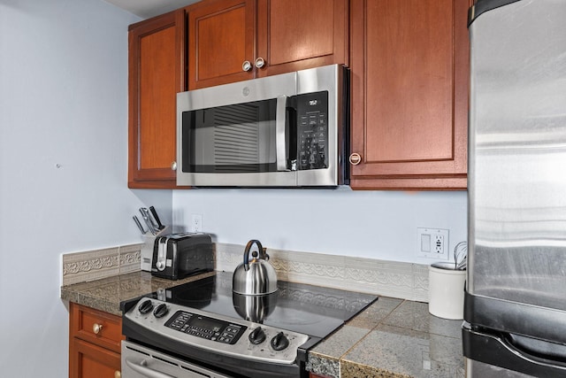 kitchen featuring brown cabinets, tile countertops, and appliances with stainless steel finishes