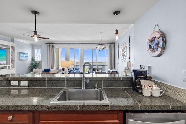 kitchen with crown molding, ceiling fan, a sink, dishwasher, and tile counters
