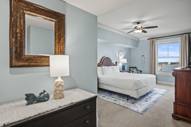 carpeted bedroom featuring crown molding, a ceiling fan, and baseboards