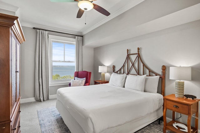 bedroom featuring ornamental molding, light carpet, baseboards, a water view, and a ceiling fan