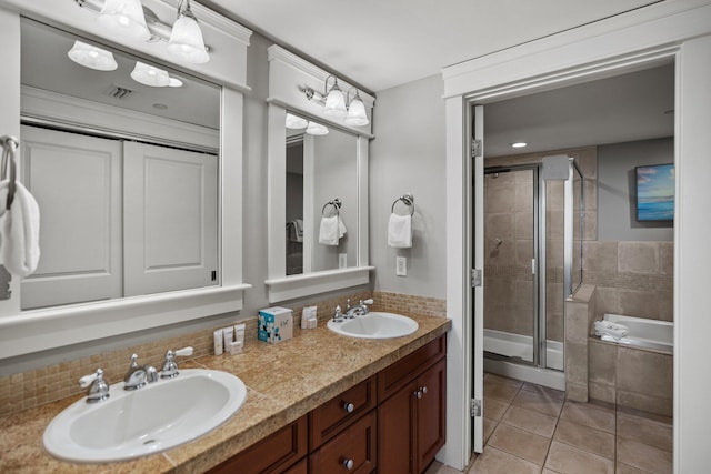 bathroom featuring a garden tub, a sink, a stall shower, and tile patterned floors