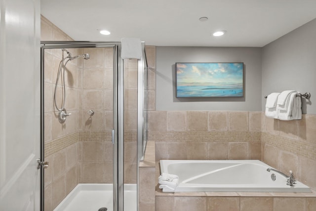 bathroom with a stall shower, recessed lighting, and a bath