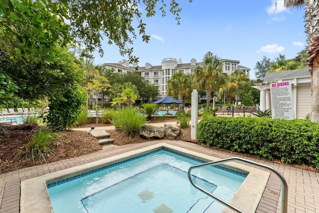view of swimming pool with a hot tub