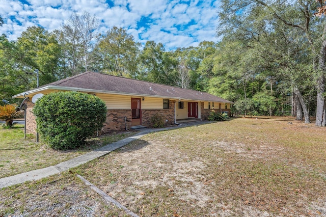 ranch-style house with a front yard, fence, and brick siding