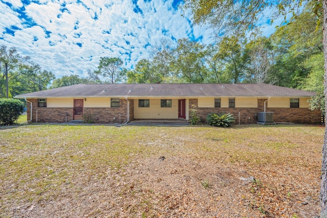 ranch-style house with brick siding, central AC unit, and a front yard