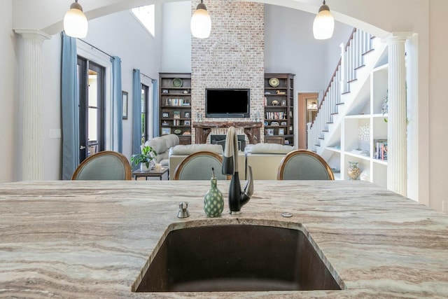 dining area featuring decorative columns, a high ceiling, and stairs