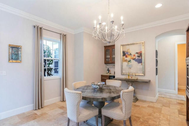 dining room featuring ornamental molding, arched walkways, and baseboards