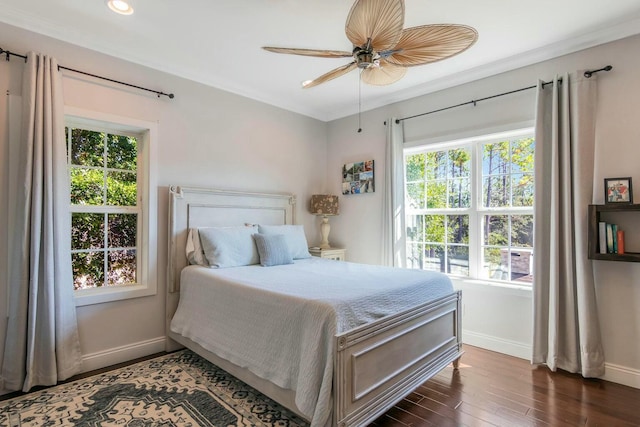 bedroom featuring ceiling fan, ornamental molding, wood finished floors, and baseboards