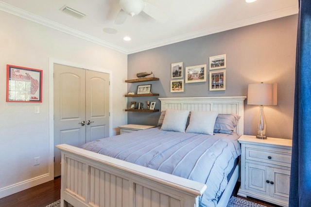 bedroom with visible vents, baseboards, a closet, dark wood-style floors, and crown molding