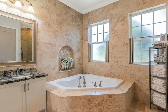 bathroom featuring a garden tub, ornamental molding, tile walls, and vanity