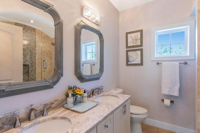 full bathroom featuring baseboards, a sink, a shower stall, and toilet