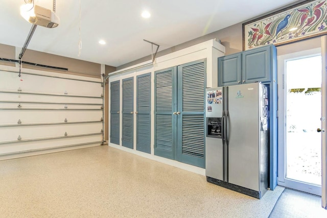 garage with a garage door opener, recessed lighting, and stainless steel refrigerator with ice dispenser