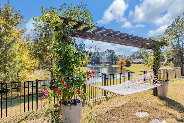 view of yard featuring a water view, fence, and a pergola