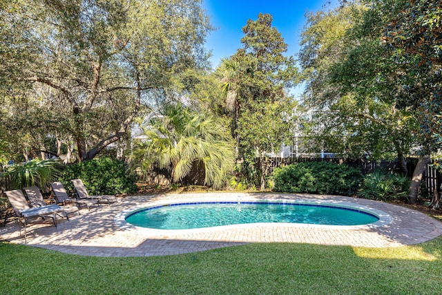 view of swimming pool featuring a fenced backyard, a fenced in pool, a lawn, and a patio