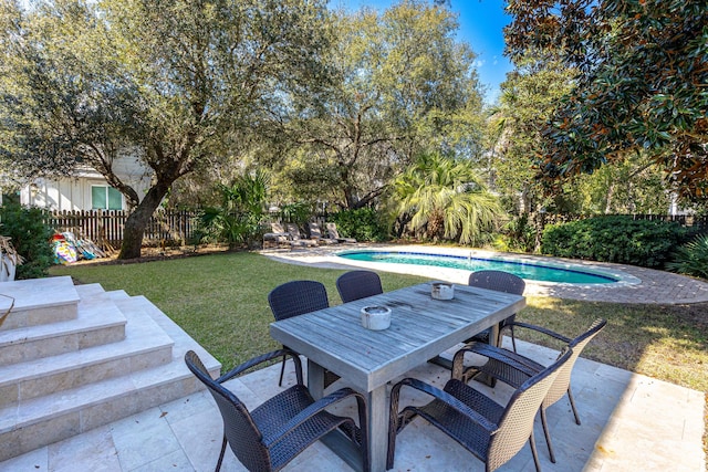 view of patio / terrace featuring fence, outdoor dining area, and a fenced in pool