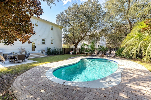 view of pool with entry steps, a fenced in pool, a fenced backyard, a yard, and a patio area