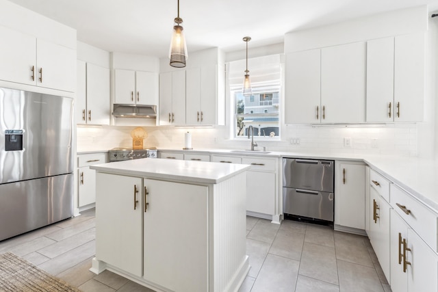 kitchen featuring under cabinet range hood, tasteful backsplash, appliances with stainless steel finishes, and a sink