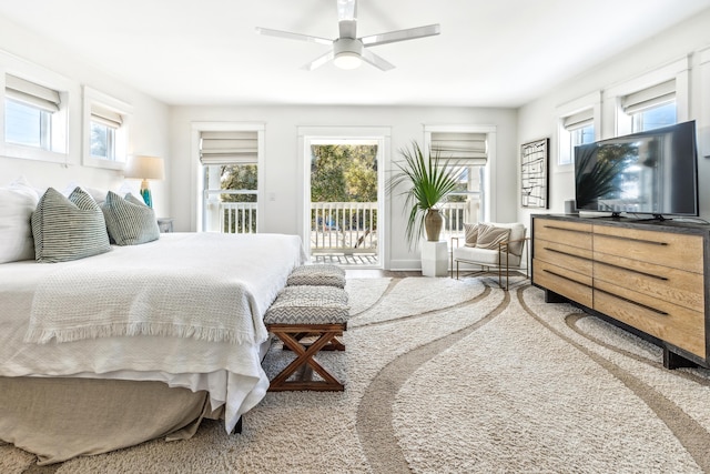 bedroom with multiple windows, a ceiling fan, and access to exterior