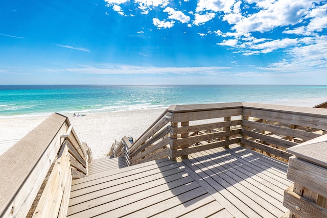 view of property's community featuring a water view and a beach view