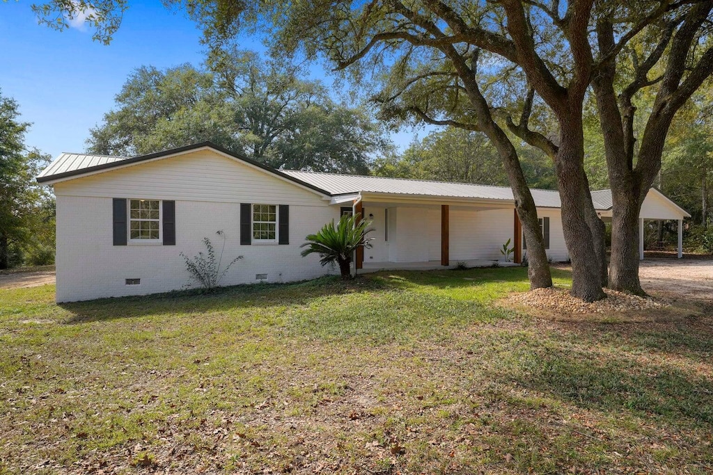 ranch-style house with crawl space, metal roof, and a front lawn