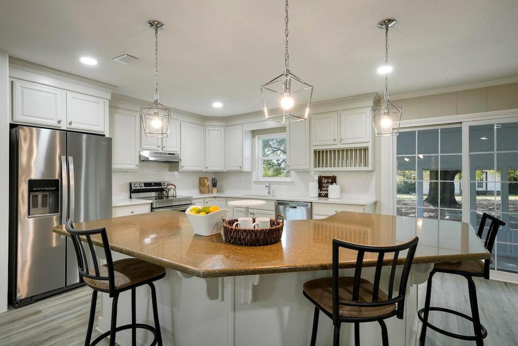 kitchen featuring under cabinet range hood, white cabinets, visible vents, and appliances with stainless steel finishes