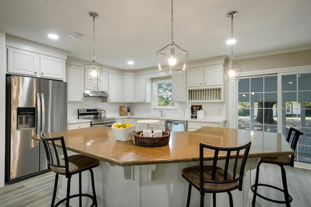 kitchen featuring under cabinet range hood, white cabinets, visible vents, and appliances with stainless steel finishes