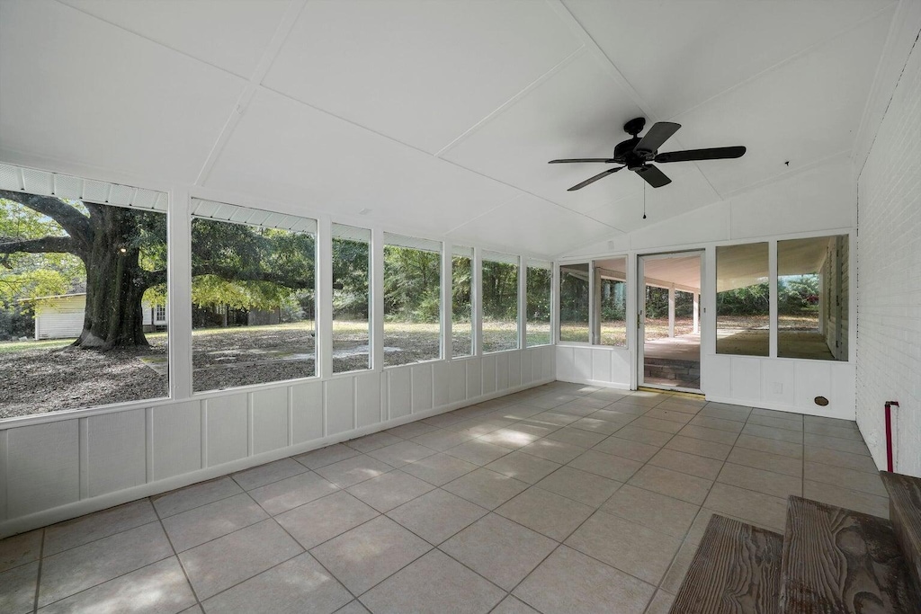 unfurnished sunroom featuring ceiling fan and vaulted ceiling