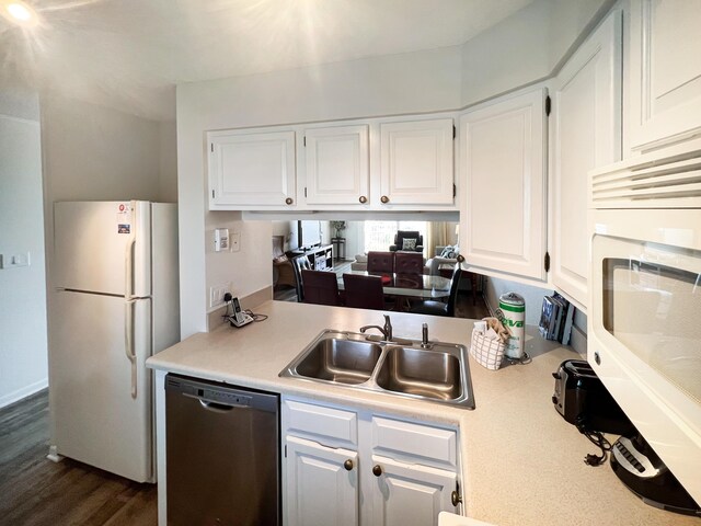 kitchen with white appliances, white cabinets, a sink, and light countertops