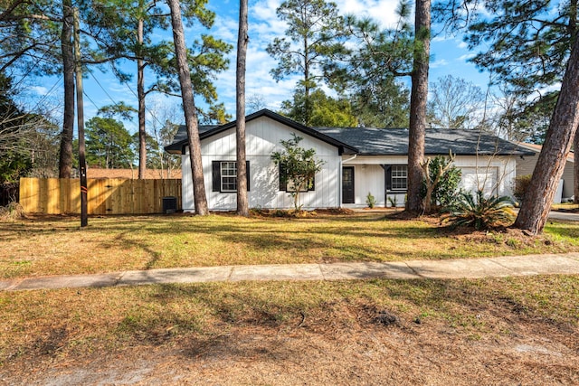 view of front facade featuring a garage, a front yard, and fence