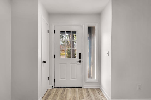 doorway to outside featuring light wood-type flooring and baseboards