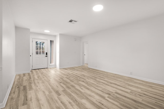 spare room with light wood-style floors, visible vents, and baseboards