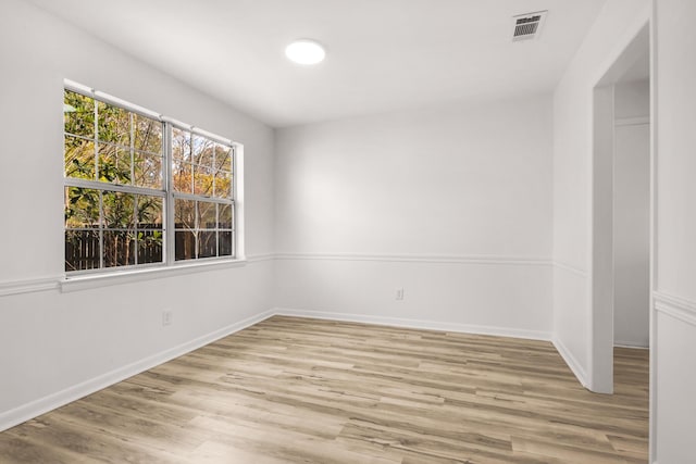 unfurnished room with visible vents, baseboards, and wood finished floors