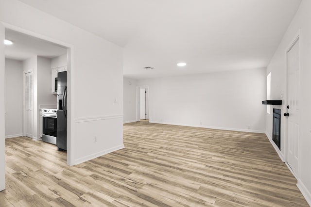 unfurnished living room with light wood finished floors, visible vents, baseboards, and recessed lighting