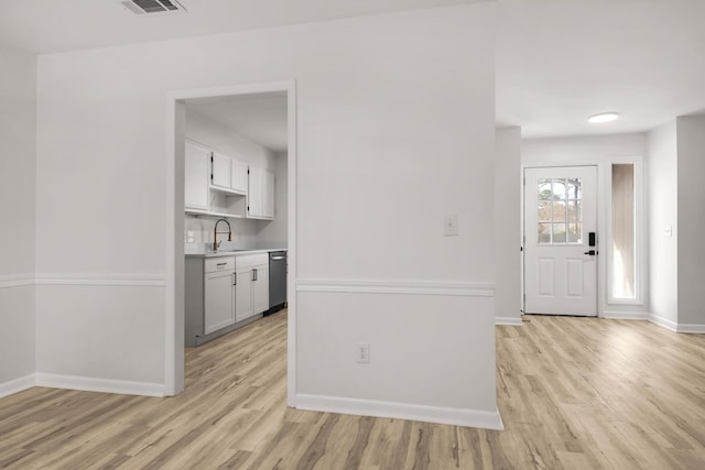 interior space with light wood-type flooring, visible vents, and baseboards