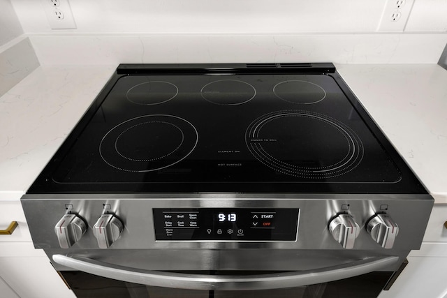 interior details featuring light stone counters and electric range