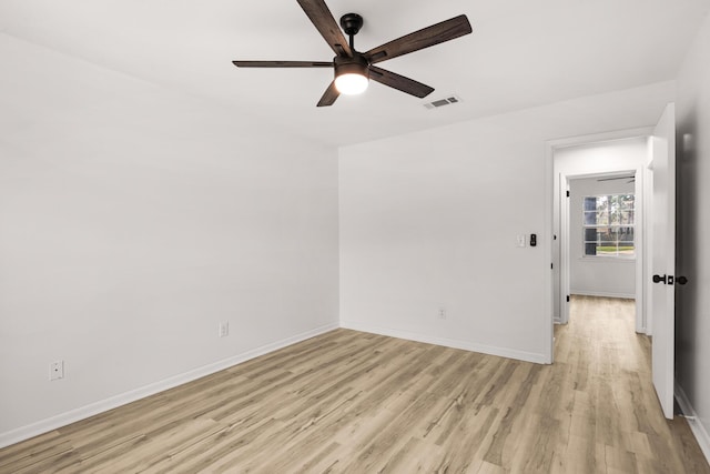 empty room with baseboards, visible vents, and light wood-style floors