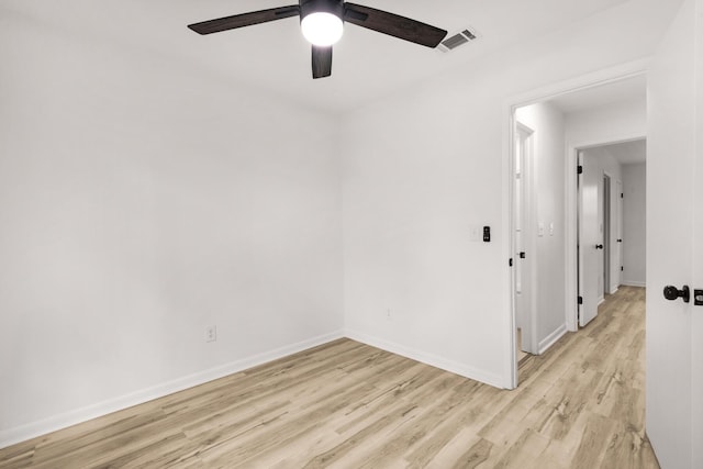 spare room featuring baseboards, ceiling fan, visible vents, and light wood-style floors