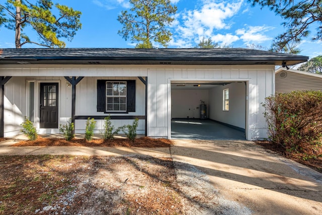 garage featuring water heater, driveway, and a porch