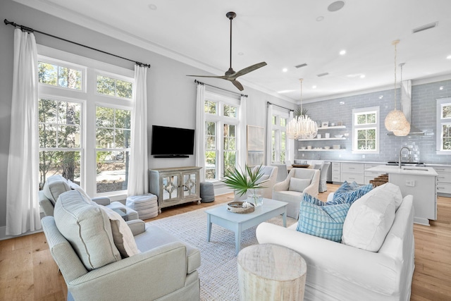 living room with light wood finished floors, recessed lighting, visible vents, and ornamental molding