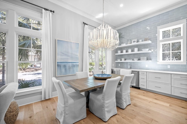 dining room with light wood-style flooring and an inviting chandelier