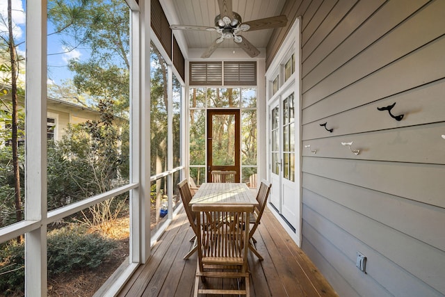 unfurnished sunroom featuring beam ceiling and ceiling fan