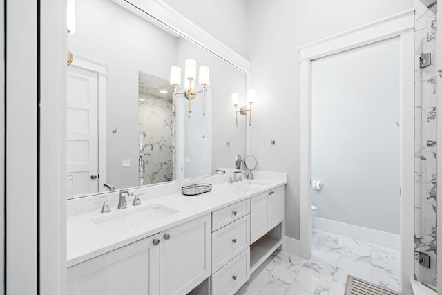 bathroom featuring a marble finish shower, baseboards, toilet, marble finish floor, and a sink