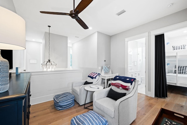 living area with light wood-style floors, visible vents, and a ceiling fan