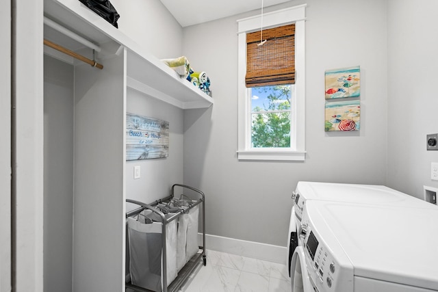 clothes washing area featuring marble finish floor, laundry area, independent washer and dryer, and baseboards