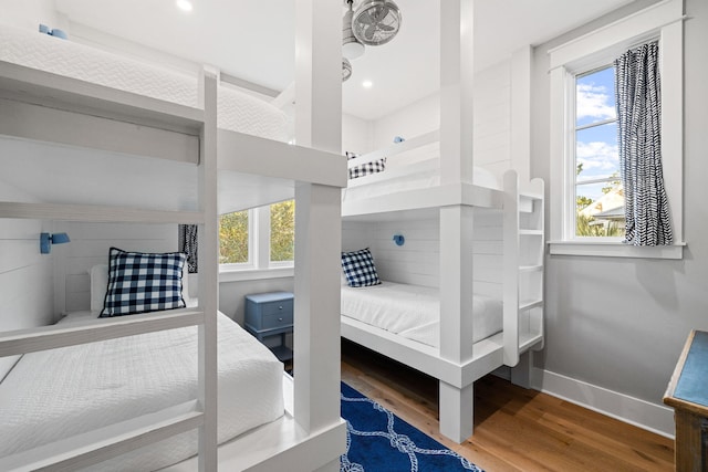 bedroom with multiple windows, recessed lighting, wood finished floors, and baseboards